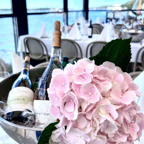 Rosa blommor och vinflaskor.